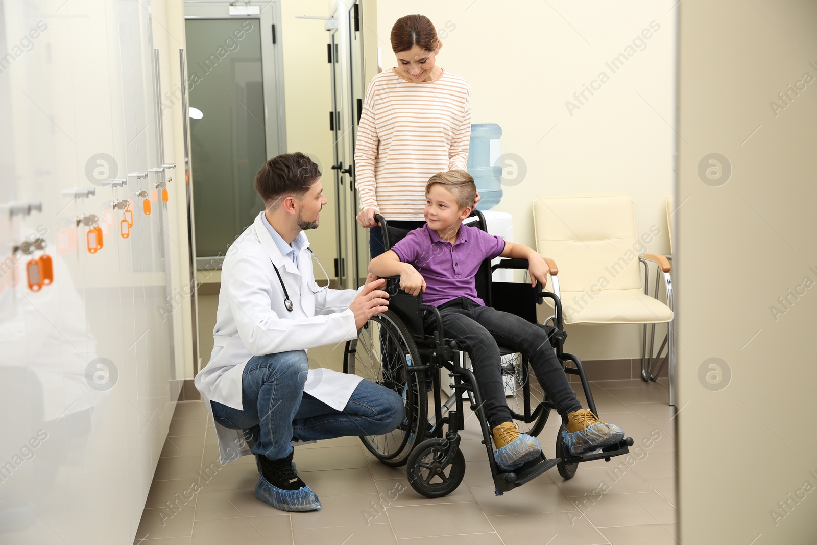 Photo of Doctor with woman and her child in wheelchair at hospital