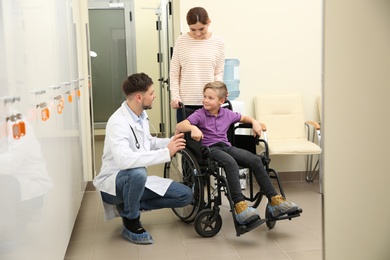 Doctor with woman and her child in wheelchair at hospital