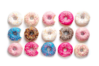 Delicious doughnuts with sprinkles on light background, top view