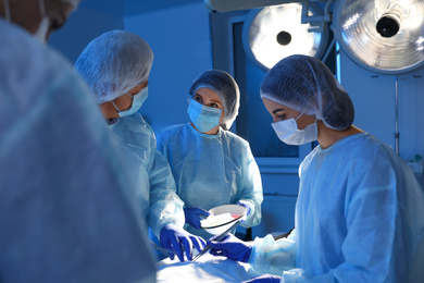 Team of professional doctors performing operation in surgery room