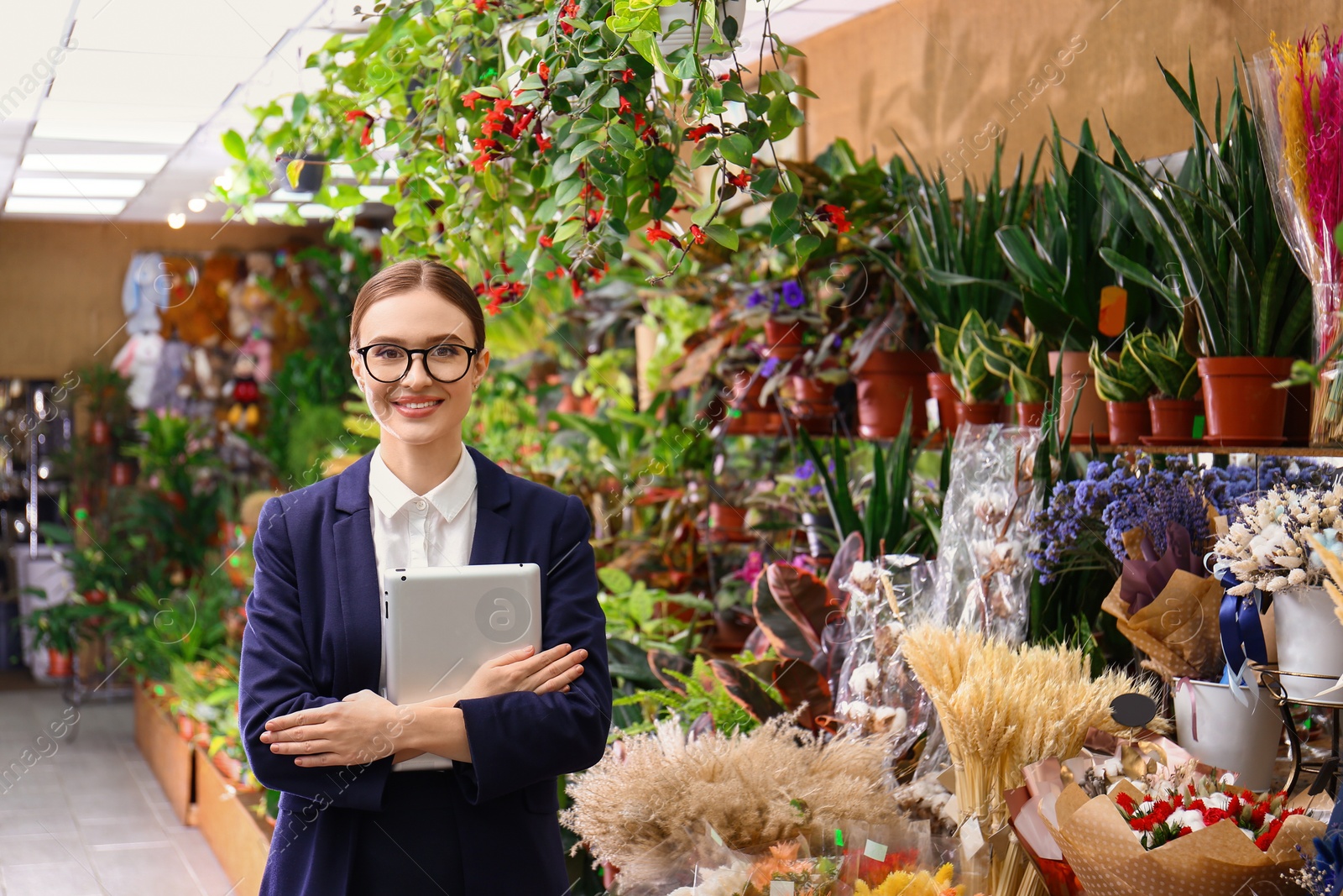 Photo of Female business owner with tablet in flower shop