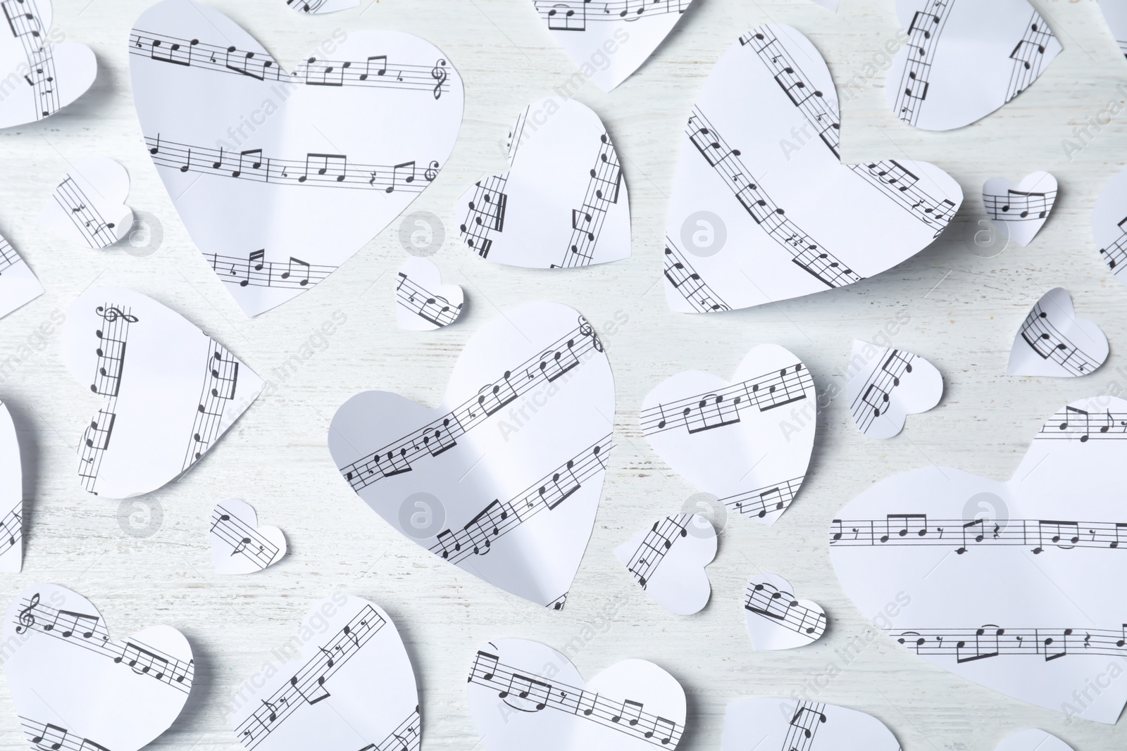 Photo of Paper hearts with music notes on white wooden background, flat lay