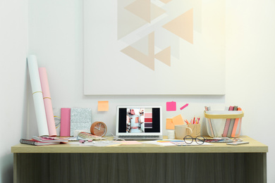 Photo of Designer's workplace with modern laptop and color palettes 