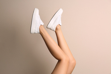 Photo of Woman wearing shoes on beige background, closeup