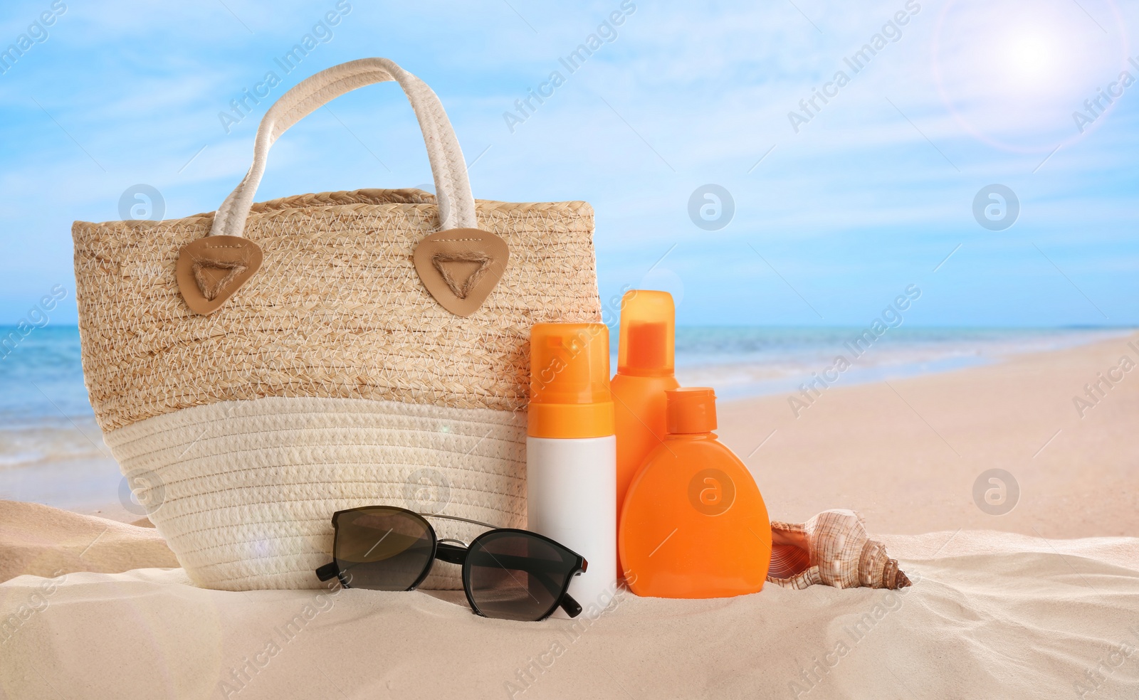 Image of Different beach accessories on sand near ocean