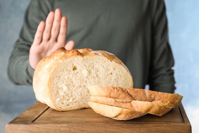 Man refusing to eat bread, closeup. Food allergy concept