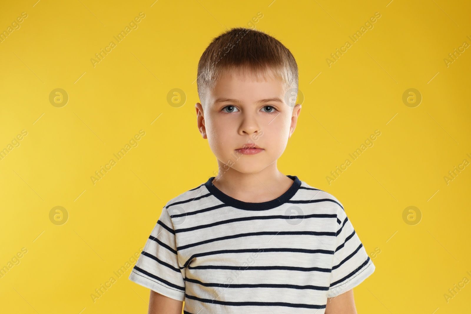 Photo of Portrait of little boy on yellow background