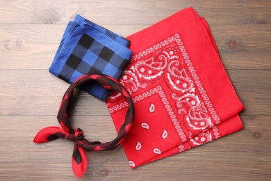 Stylish bandanas with different patterns on wooden table, flat lay