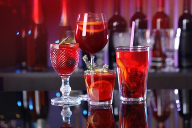 Photo of Many glasses of delicious refreshing sangria on counter in bar