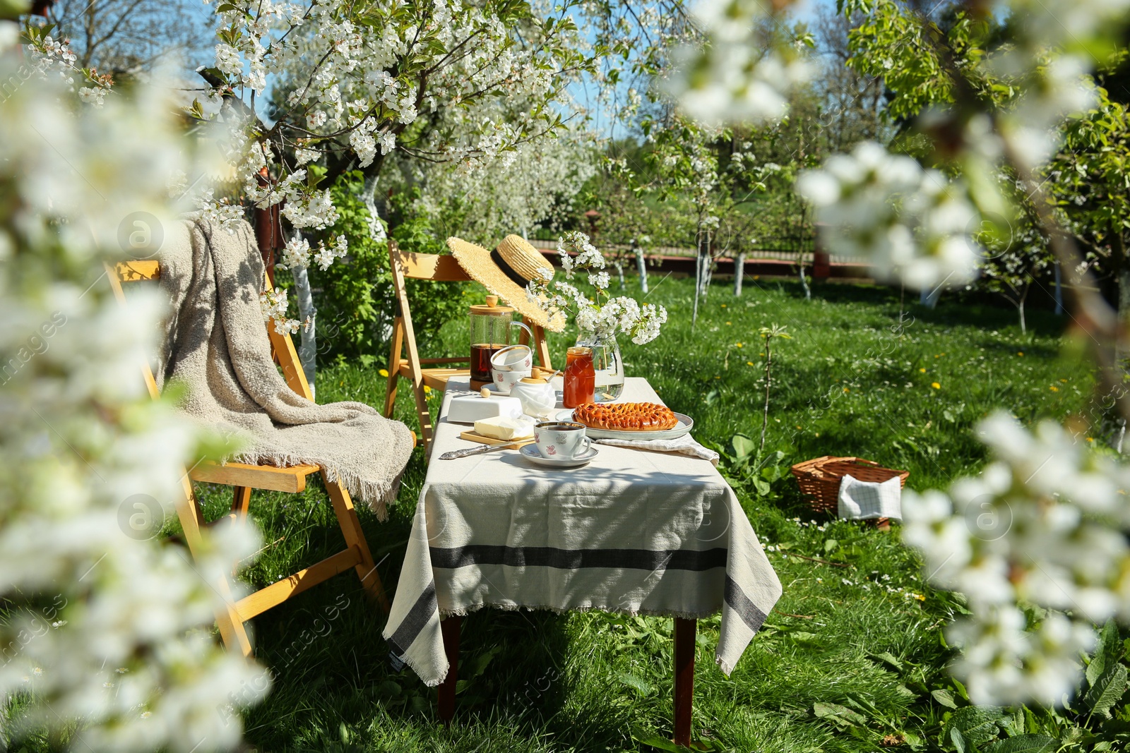 Photo of Beautiful table setting with spring flowers in garden on sunny day