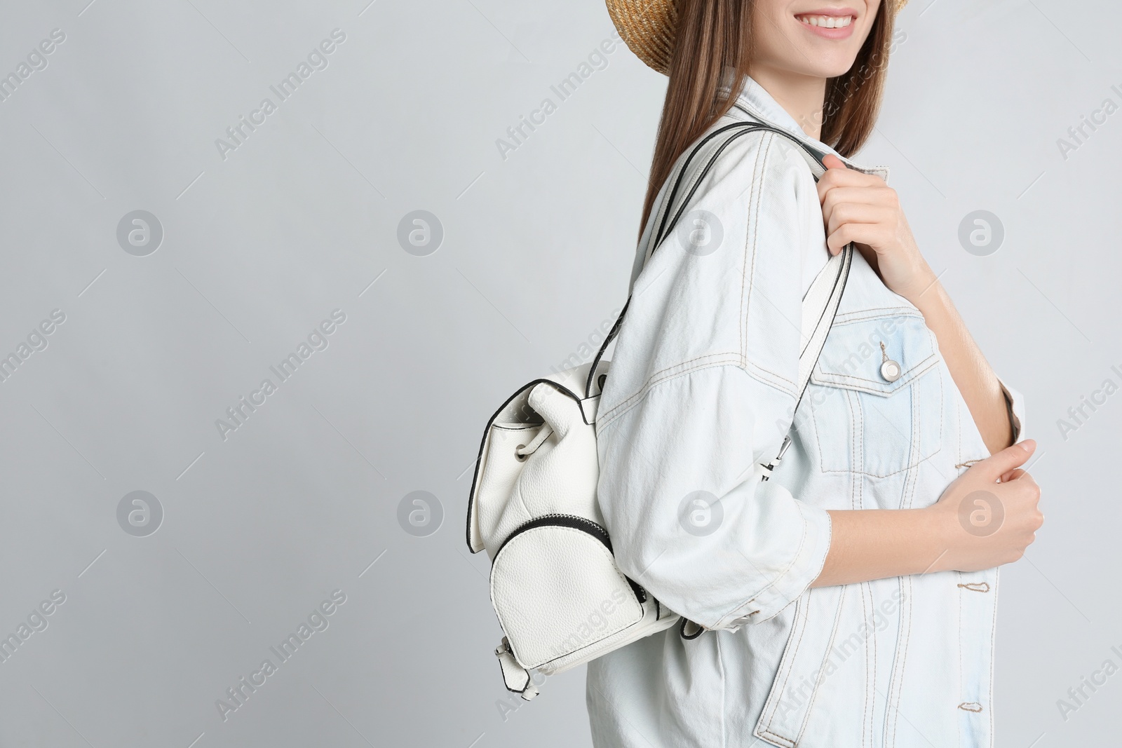 Photo of Young woman with stylish bag on grey background, closeup. Space for text