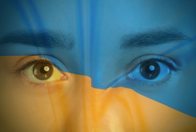 Double exposure of Ukrainian national flag and young woman, closeup view