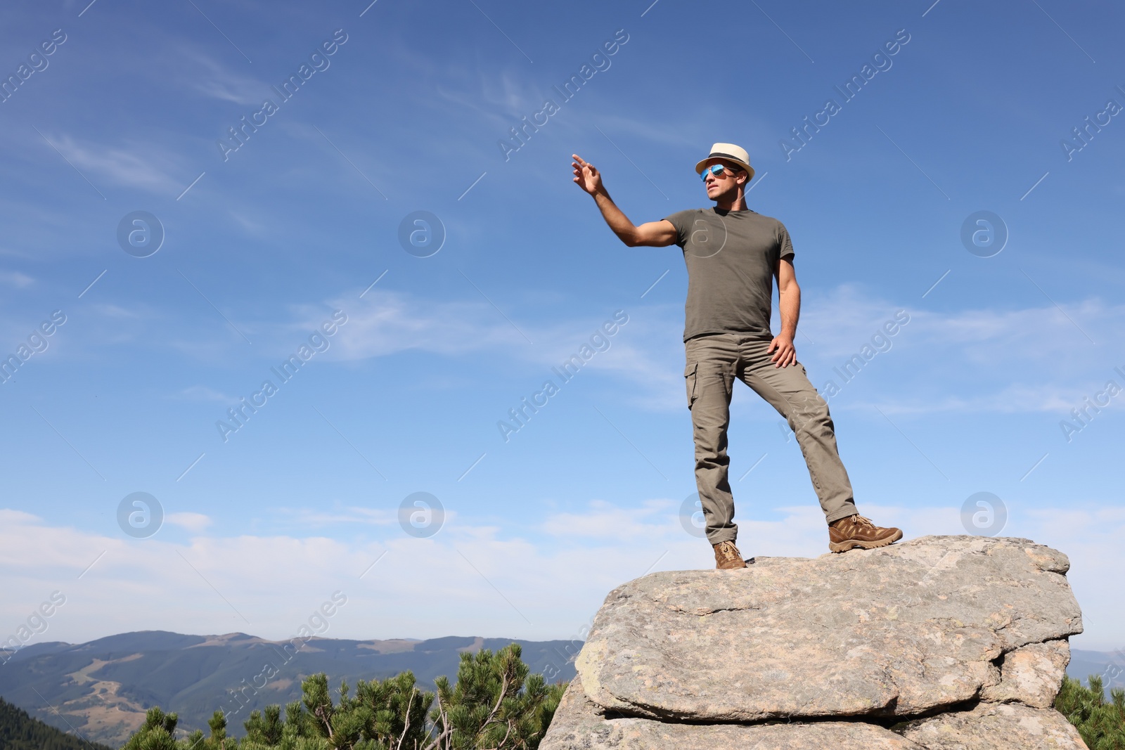 Photo of Man enjoying picturesque view on cliff in mountains. Space for text