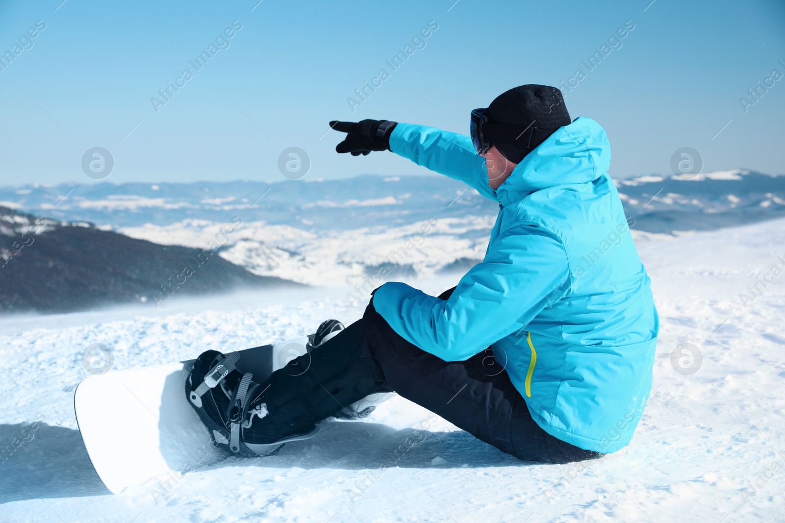 Photo of Man with snowboard on hill. Winter vacation