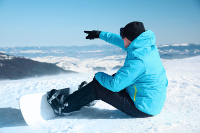 Man with snowboard on hill. Winter vacation