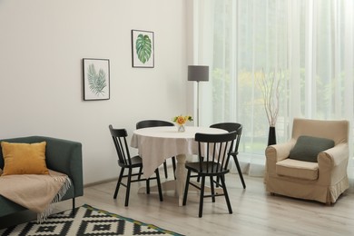Photo of Dining table with chairs in living room. Interior design