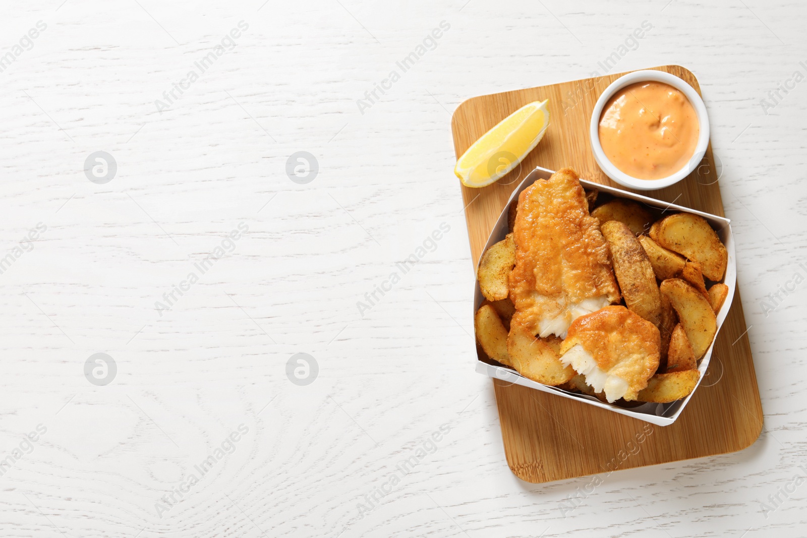 Photo of Disposable container with British Traditional Fish and potato chips on wooden background, top view. Space for text