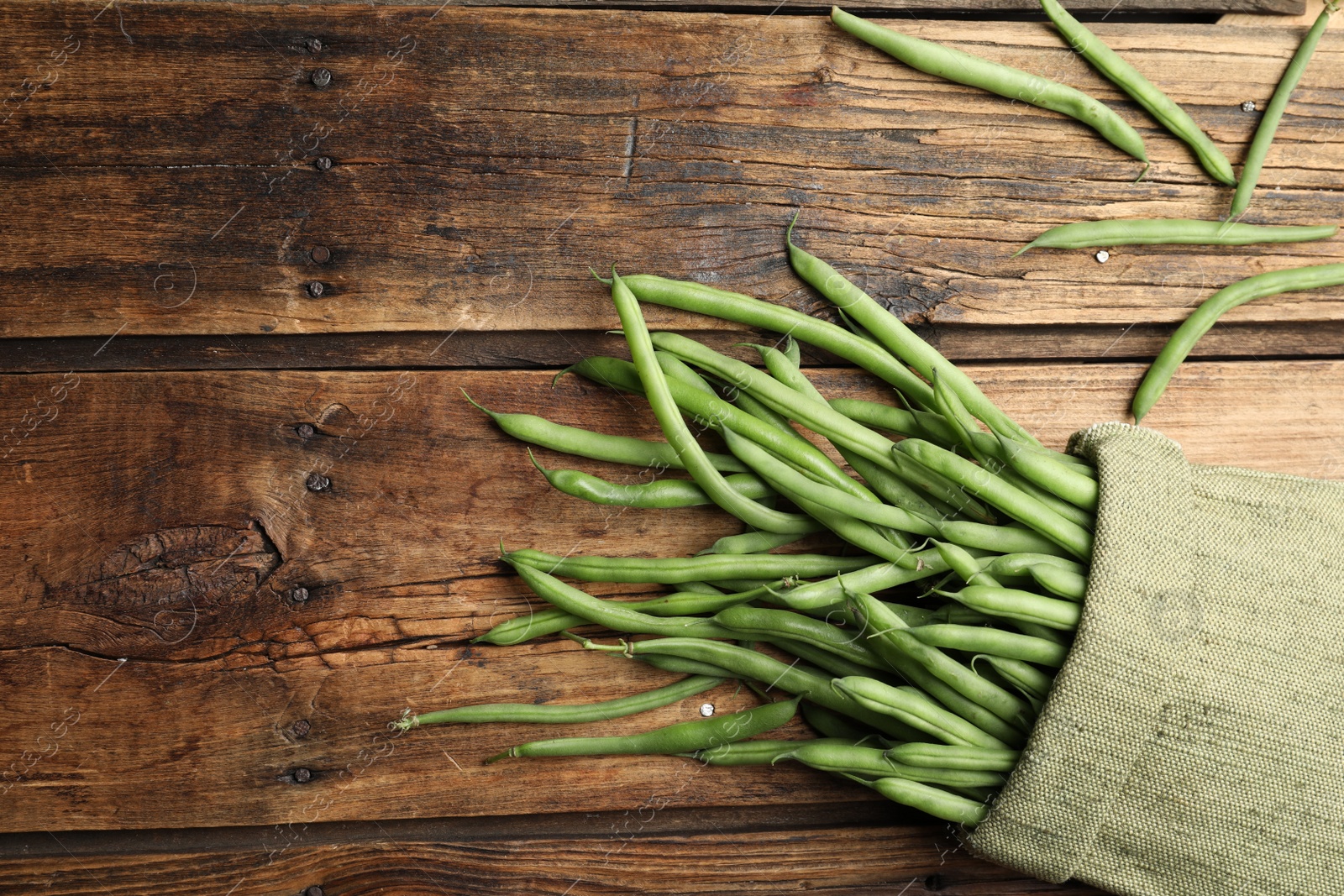 Photo of Fresh green beans on wooden table, flat lay. Space for text