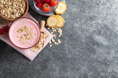 Photo of Glass of tasty berry smoothie with oatmeal on grey table, flat lay. Space for text