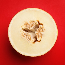 Half of ripe tasty melon on red background, top view