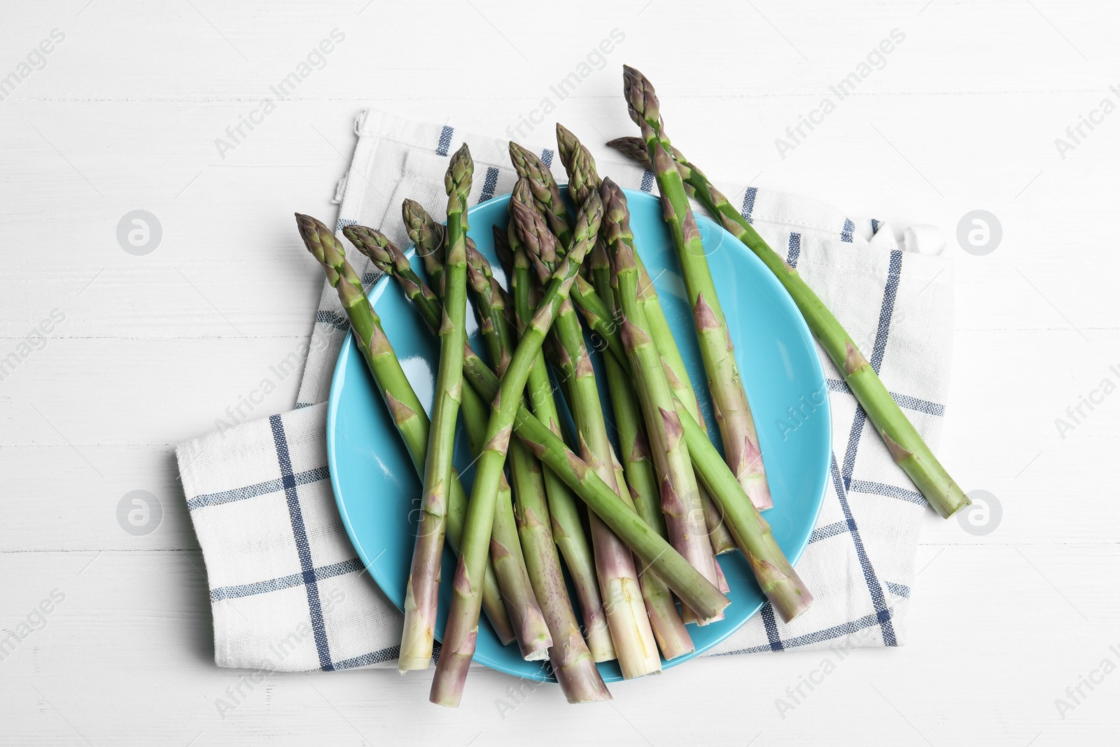 Photo of Fresh raw asparagus on white table, flat lay