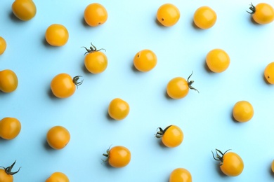 Photo of Yellow tomatoes on light blue background, flat lay