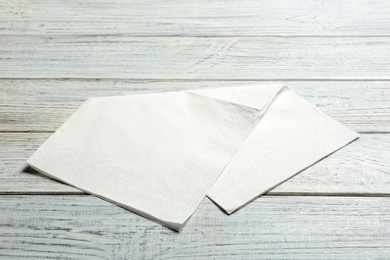 Clean paper napkin on wooden background. Personal hygiene