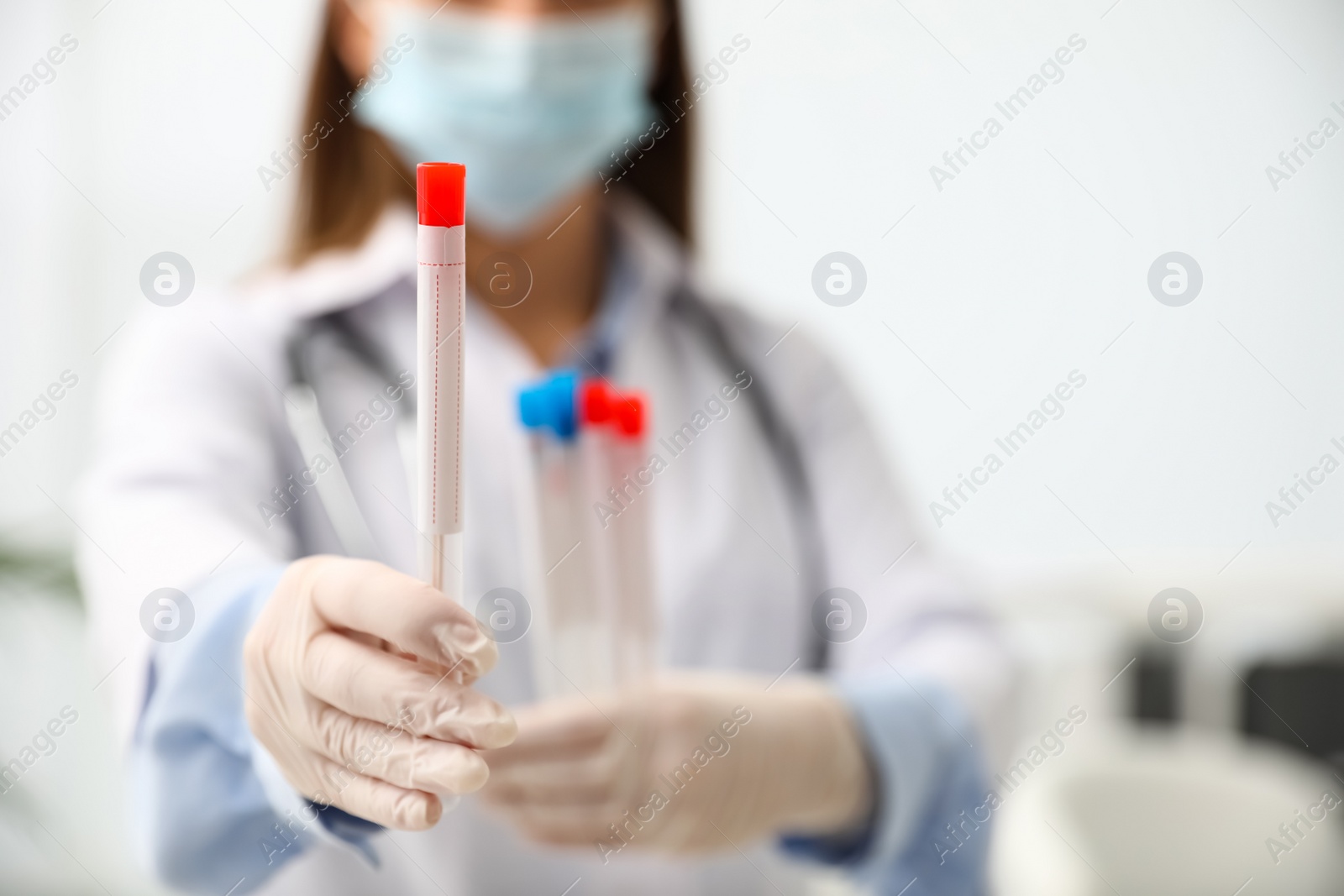 Photo of Doctor holding tubes with cotton swabs for DNA test in clinic, closeup