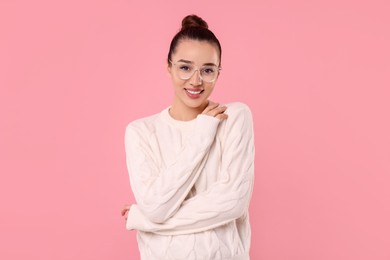 Photo of Beautiful young woman in stylish warm sweater on pink background