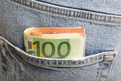 Photo of Euro banknotes in pocket of jeans, closeup. Spending money