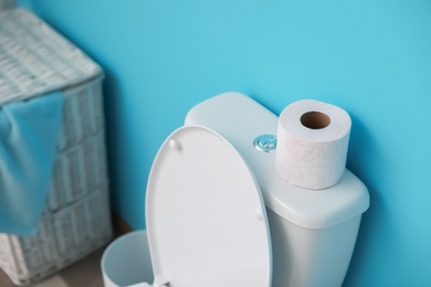 Paper roll on toilet tank in bathroom