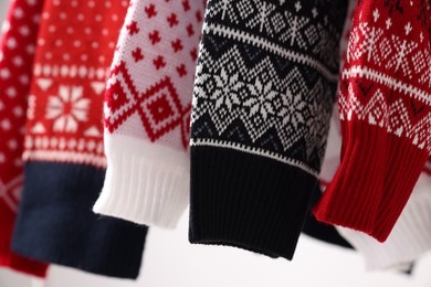 Closeup view of many different Christmas sweaters