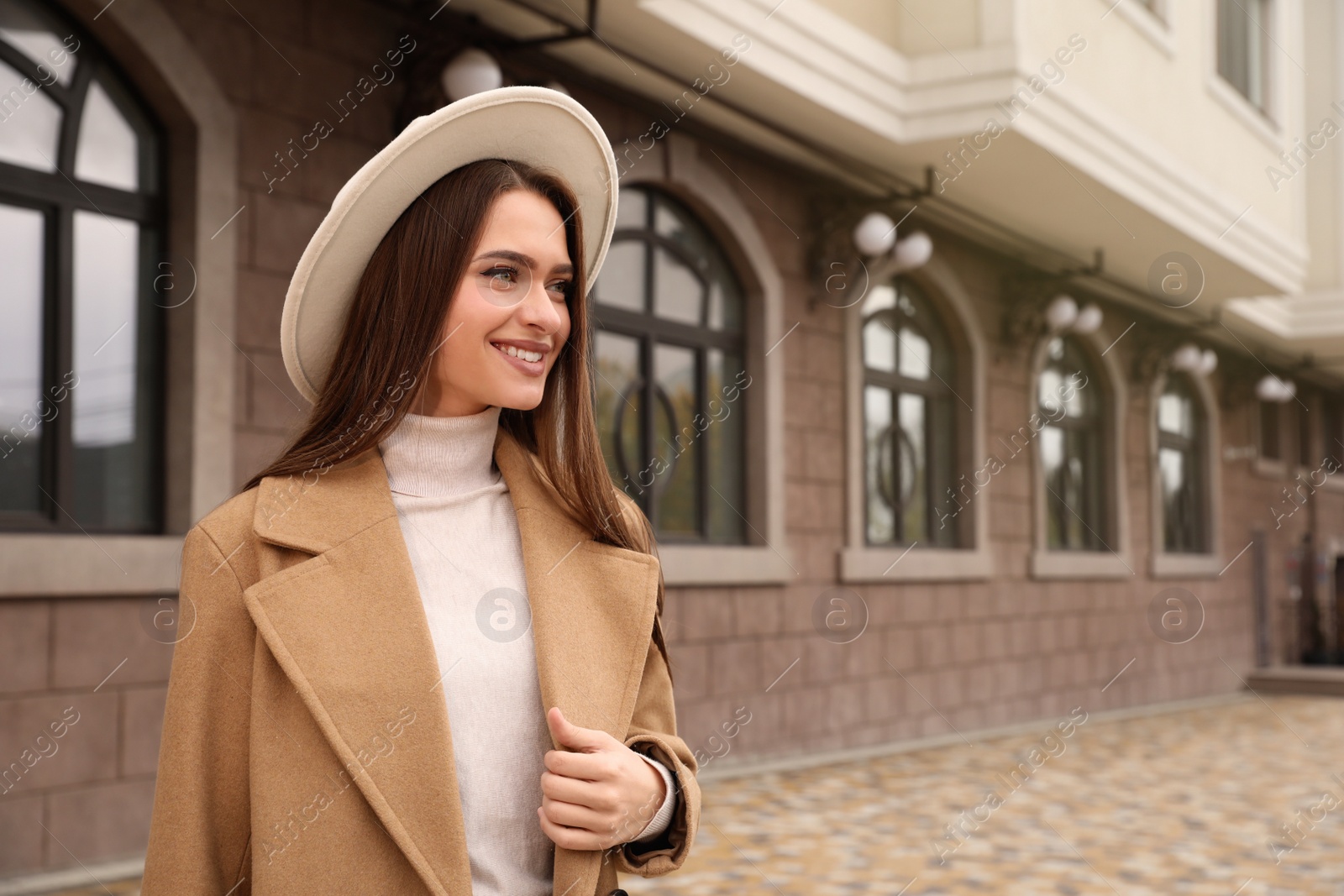 Photo of Beautiful young woman wearing stylish autumn clothes on city street