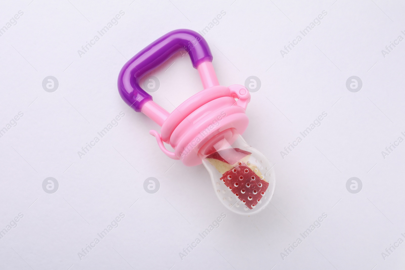 Photo of Nibbler with apple on white background, top view. Baby feeder