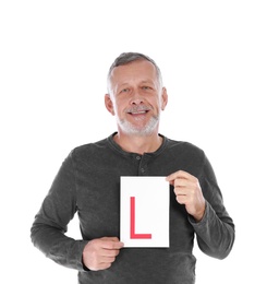 Happy mature man with L-plate on white background. Getting driving license