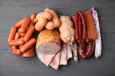 Photo of Different types of sausages on light grey wooden table, above view