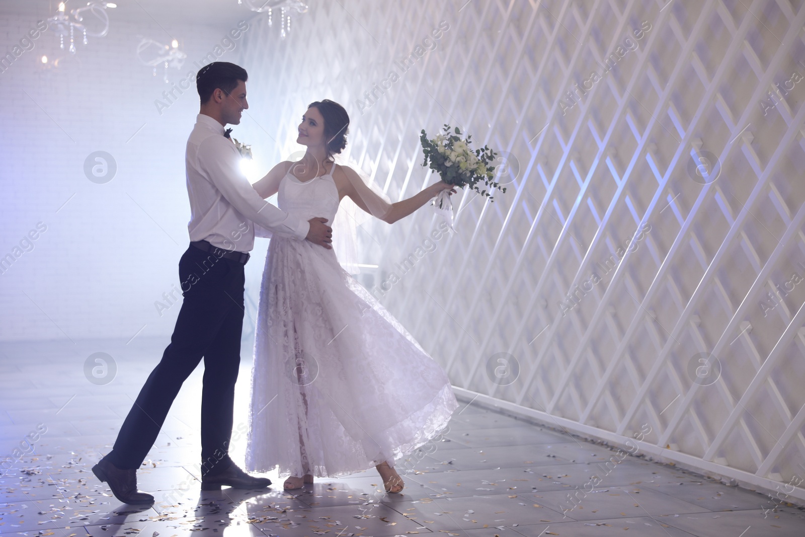 Photo of Happy newlywed couple dancing together in festive hall