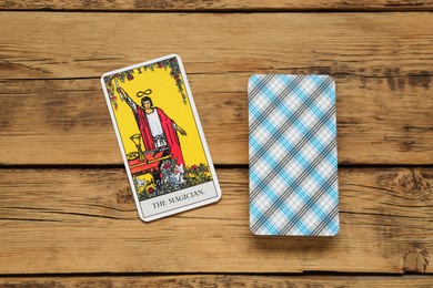 Photo of The Magician and other tarot cards on wooden table, flat lay