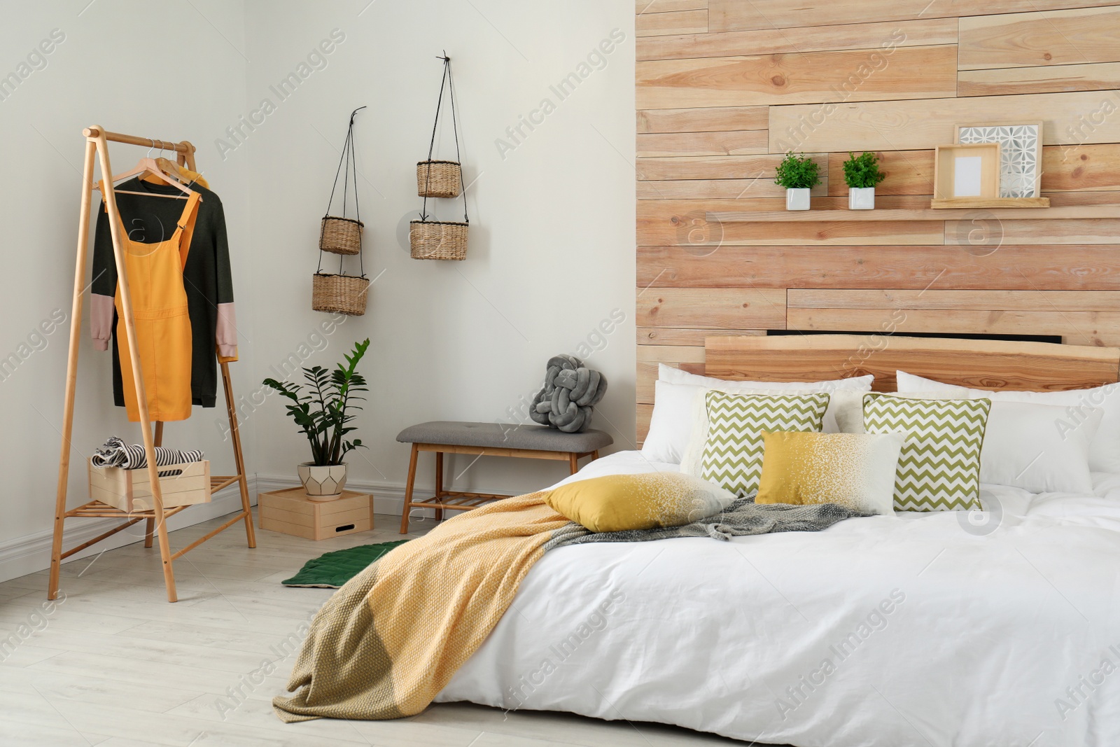 Photo of Stylish room interior with comfortable bed near wooden wall