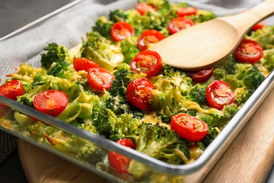 Photo of Tasty broccoli casserole in baking dish on table, closeup