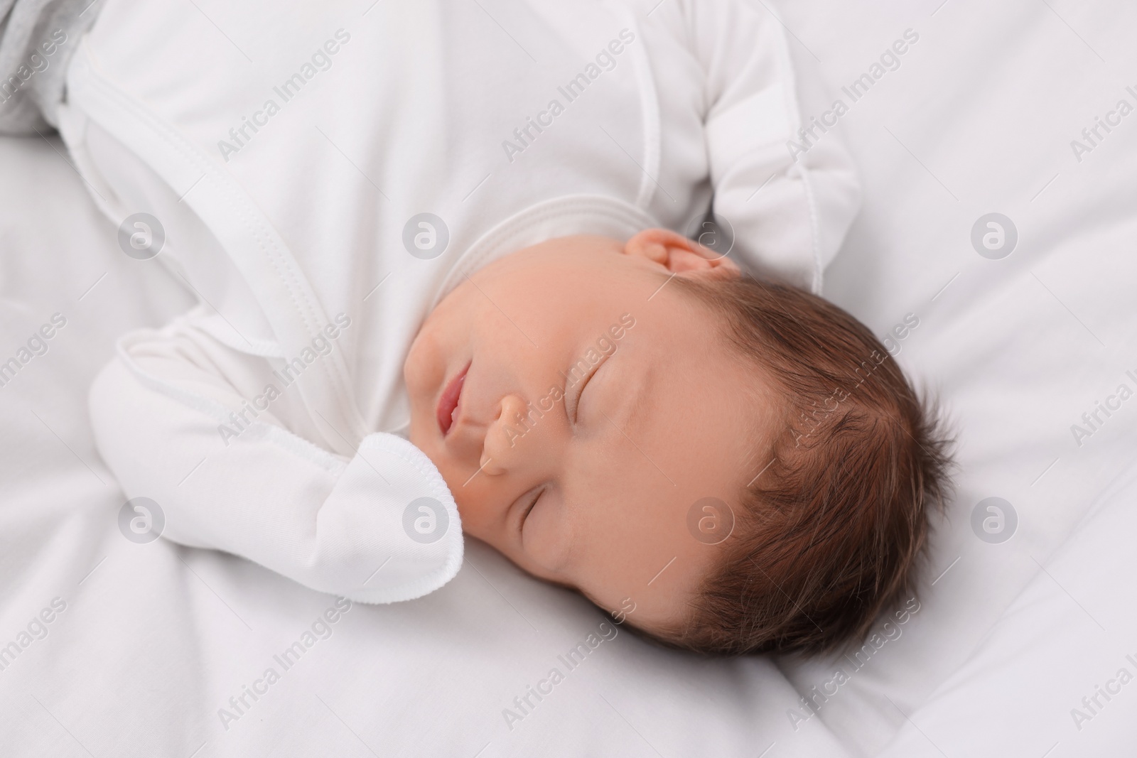 Photo of Cute newborn baby sleeping on white bed