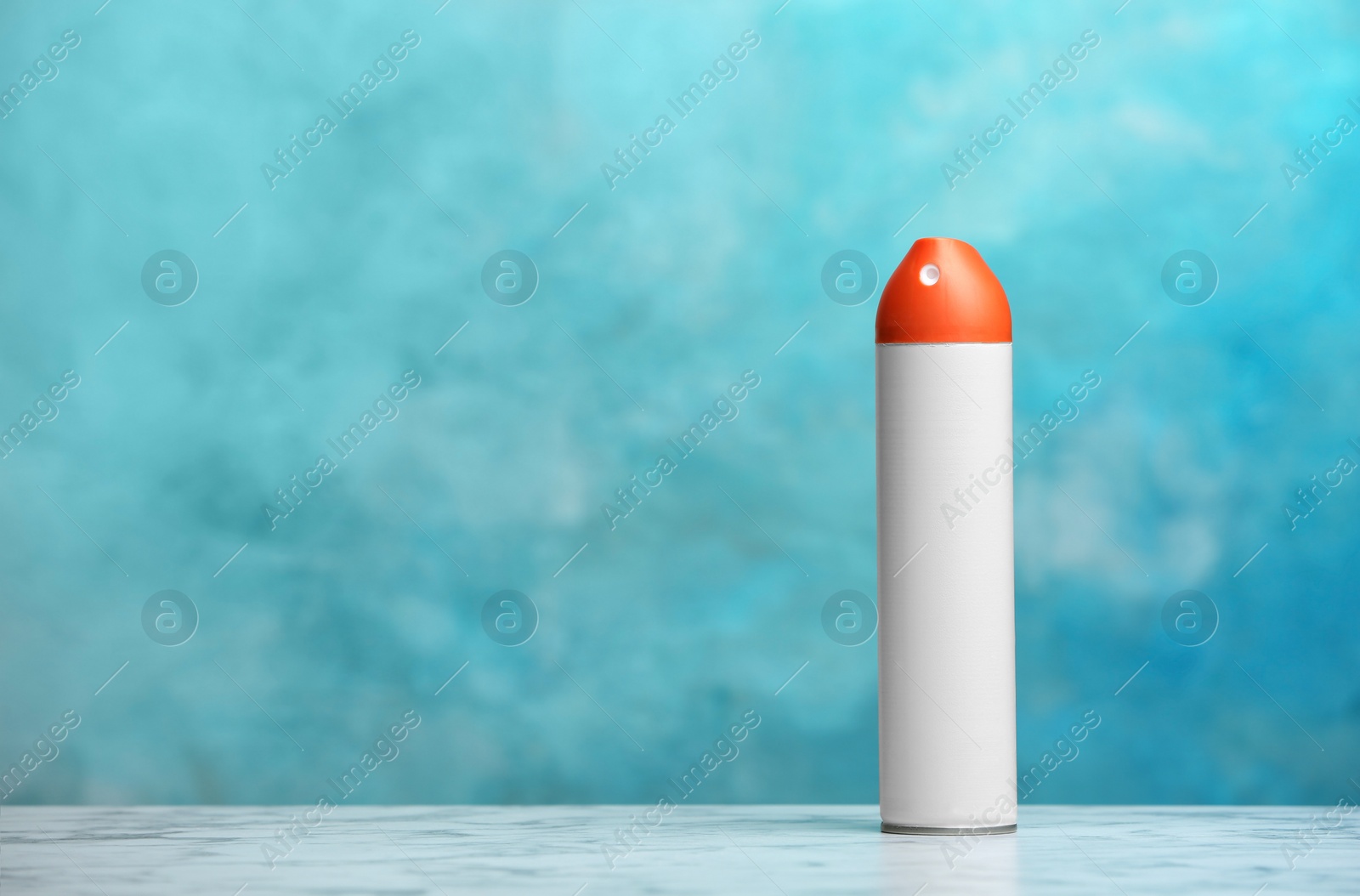 Photo of Spray air freshener on table against color background