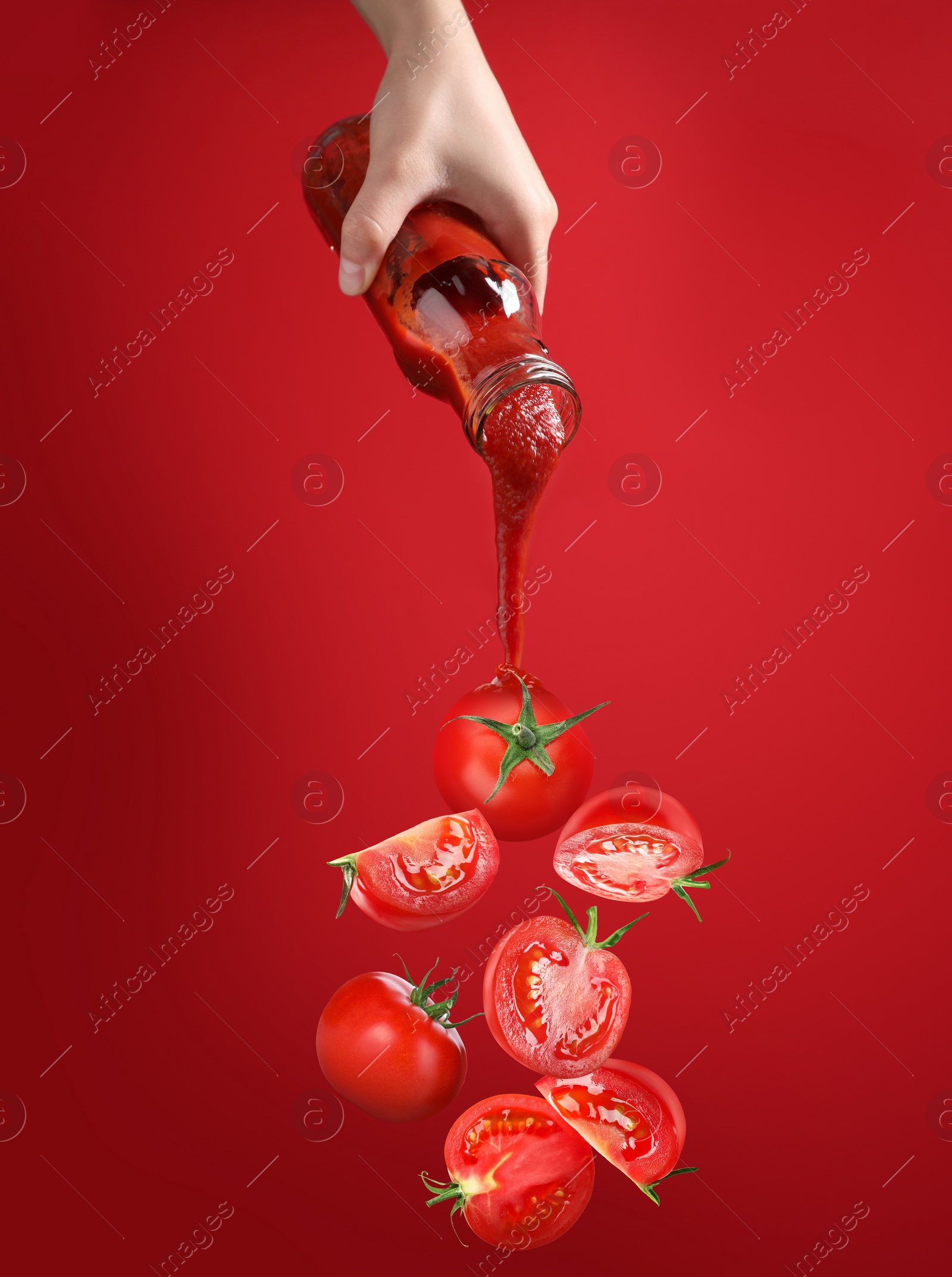 Image of Woman pouring organic ketchup onto tomato against red background, closeup