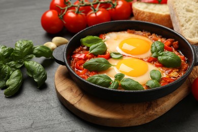 Photo of Delicious Shakshuka served on grey textured table, closeup