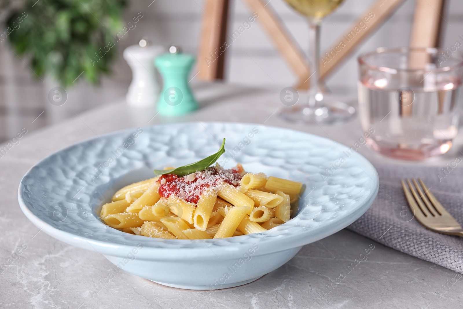 Photo of Delicious pasta with tomato sauce served on light marble table