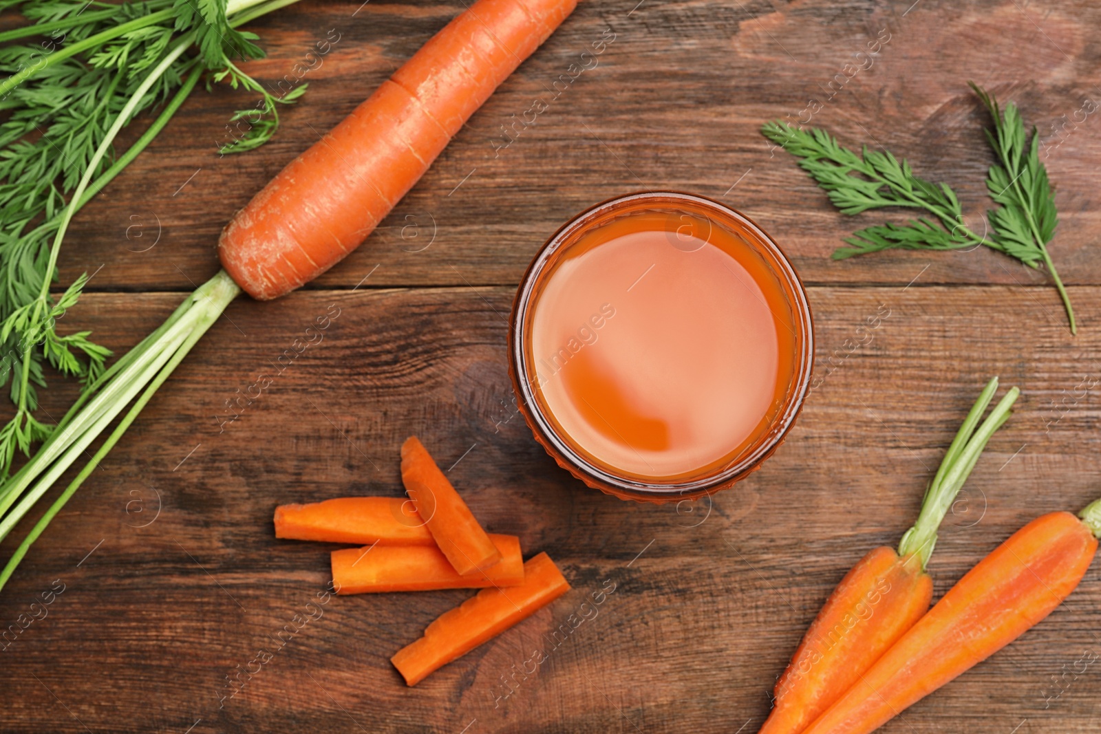 Photo of Flat lay composition with carrots and juice on wooden table