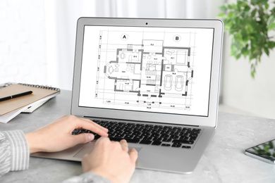Image of Architect making project of house on laptop in office, closeup