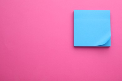 Paper note on pink background, top view. Space for text