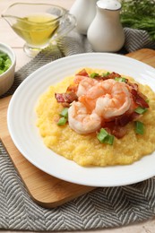 Photo of Plate with fresh tasty shrimps, bacon, grits and green onion on table, closeup