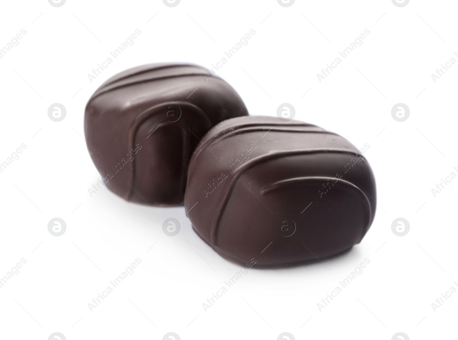 Photo of Delicious dark chocolate candies isolated on white